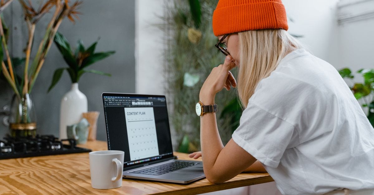 Business owner checking AI receptionist messages and website on a laptop